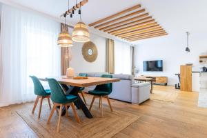 a living room with a table and green chairs at Marina Deluxe - największy apartament na Marinie widok na jezioro, winda, 2 balkony, klima in Iława +32 photos