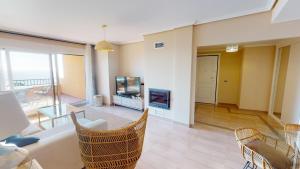 a living room with a couch and a tv and a table at Penthouse Bonita Vista al Mar in Águilas