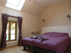 een slaapkamer met een paars bed en een raam bij Le Repos Coquelicot in Montillot