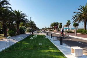 a person riding a bike down a street with a park at Hotel Cristallo in Giulianova