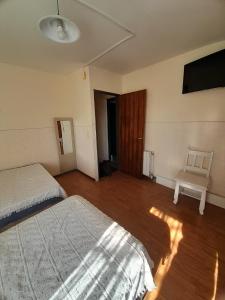 una camera da letto con due letti e una sedia di El chilco a San Carlos de Bariloche