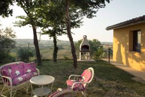 een patio met stoelen, een tafel en een grill bij Casa Vacanze Angelica in Ostra Vetere