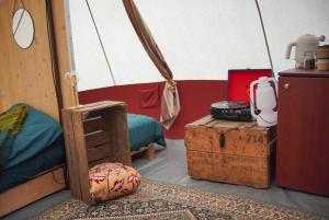 a room with a tent with a bed and a table at Kampeerbeleving Dijksehoeve in Nistelrode