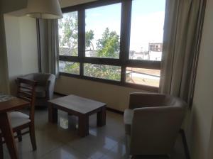 een kamer met een tafel en stoelen en een groot raam bij EDIFICIO BARROS in Olavarría