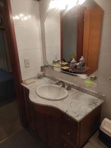 een badkamer met een wastafel en een spiegel bij EDIFICIO BARROS in Olavarría +10 foto's