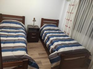twee bedden naast elkaar in een kamer bij EDIFICIO BARROS in Olavarría