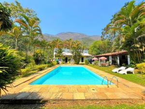 una piscina davanti a una casa di Sítio Primavera em Petrópolis - Região do Vale Florido a Inglesa