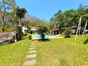 un cortile con piscina e palme di Sítio Primavera em Petrópolis - Região do Vale Florido a Inglesa