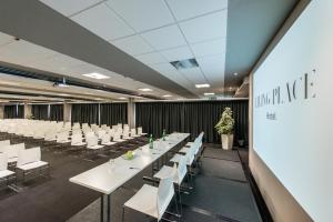 a conference room with white tables and white chairs at Living Place Hotel in Villanova