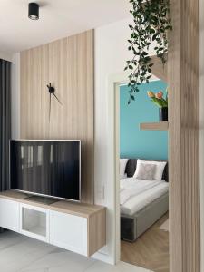 sala de estar con TV y cama en Zielony Jadeit - Ucieczka od Zgiełku - Pogorzelica, en Pogorzelica