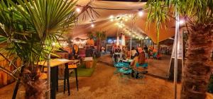 波特拉什North Coast Glamping - The Open 2025的一群人坐在餐厅的桌子旁