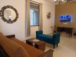 a living room with a couch and a mirror at Poolside Apartment Bliss by the Pool Goa in Candolim