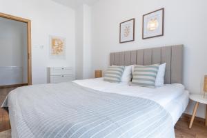 a bedroom with a large bed with a blue and white blanket at LUBAVA apartment z garażem podziemnym i klimatyzacją, Netflix, TV55', winda in Lubawa