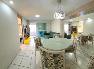 a dining room and living room with a table and chairs at Beach Class by Solemar in Fortaleza