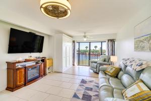 a living room with a couch and a flat screen tv at 2 Mi to Fort Pierce Jetty Coastal Florida Condo in Fort Pierce