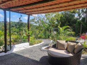 a wicker chair sitting under a pergola at Fazenda de Jehne in Camamu