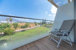 a chair on a balcony with a view at Edge Luxury Beachfront 3BR, 3 pools, spa, gym in Estepona +62 photos