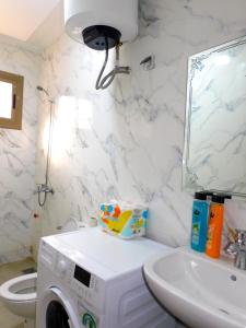 a bathroom with a washing machine and a sink at BB Appartement Cosy clim wifi 5 min de la Plage in Saidia 