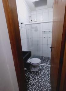 La salle de bains est pourvue de toilettes et de carrelage noir et blanc. dans l'établissement Casa na praia férias, à Vila Balneária