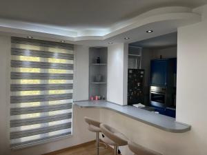 a kitchen with a counter with chairs and a window at Apartman BK LUX in Belgrade