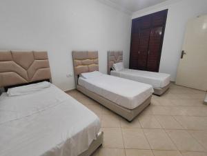 a hotel room with two beds and a cabinet at Traditional Spacious 2 Bedroom Tangier Center Family Apartment in Tangier