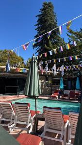 an umbrella and chairs next to a swimming pool with flags at R3 Hotel LGBTQIA All Welcome Adults Only in Guerneville +17 photos