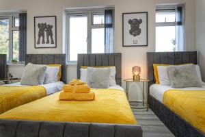 a bedroom with two beds with yellow sheets at The Hive in Coventry