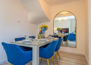 a dining room with a table and blue chairs and a mirror at The Hive in Coventry