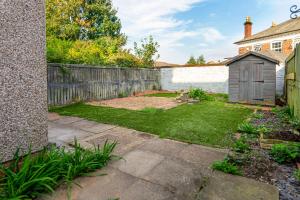 a backyard with a wooden fence and a garden at The Hive in Coventry