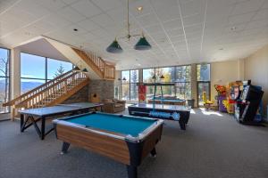 a room with two pool tables and a staircase at Treehouse #107, Building G by Summit Country Mountain Retreats in Silverthorne