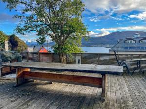 a wooden bench sitting on top of a deck at Two-Bedroom City Apartment with Fire Place, Free Parking and Fjordview Terrace - Calm and Central in Ålesund