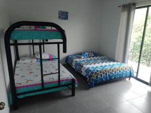 a bedroom with a bunk bed and a bed and a shelf at El eden in Carmen de Apicalá