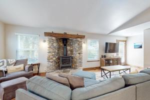 a living room with couches and a stone fireplace at Homewood Cabin Among the Pines in Homewood