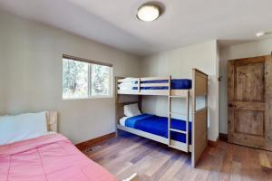 a bedroom with two bunk beds and a window at Homewood Cabin Among the Pines in Homewood
