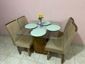 a glass table with two chairs and a vase with flowers at Casa Aconchegante de 2 quartos e 2 camas de casal in Juazeiro do Norte +19 photos