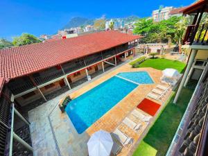 an aerial view of a house with a swimming pool at Pousada Margerie Ubatuba - Ítagua in Ubatuba