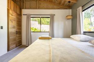 un grande letto in una stanza con una grande finestra di Casa Latte a Cabrera