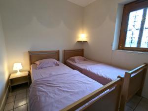 two beds in a room with a window at Gîte charmant en Sologne : balades, pêche, visites de châteaux, animaux bienvenus - FR-1-590-100 in Villemurlin