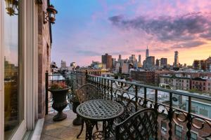 a balcony with a table and chairs and a view of a city at The Historic Blue Moon Hotel - NYC in New York