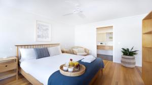 a bedroom with a bed with a tray on it at Buwarla House in Currarong