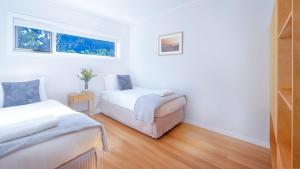 a bedroom with two beds and a window at Buwarla House in Currarong +19 photos