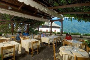 a group of people sitting at tables in a restaurant at Altavilla Locanda E Tipica Trattoria in Bianzone