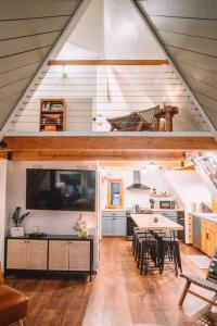 a kitchen and dining room with a table and a tv at Aframe of Mind Packwood in Packwood