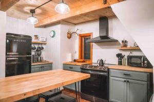 a kitchen with black appliances and a wooden counter top at Aframe of Mind Packwood in Packwood