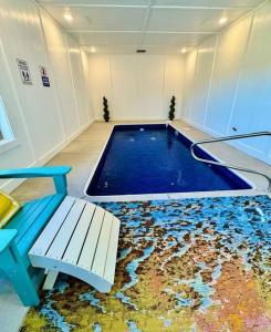 a swimming pool in a room with a bench at Enchanted Peak Lodge in Pigeon Forge