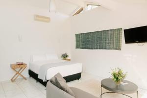 a white bedroom with a bed and a tv at Chapel Hill Winery Guest House in McLaren Vale +4 photos