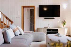 a living room with two couches and a flat screen tv at Chapel Hill Winery Guest House in McLaren Vale