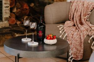 a table with two glasses and a bottle of wine and strawberries at Chapel Hill Winery Guest House in McLaren Vale