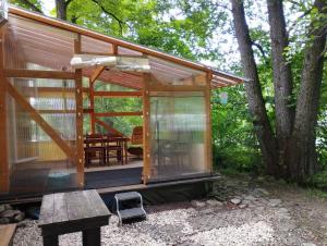 a glass house with a table in front of it at Včelín - Camp pod kaštany in Morávka