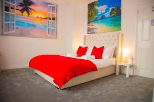 ein Schlafzimmer mit einem großen Bett mit roten Kissen in der Unterkunft Lucky Home 24 - Ideal for Trade & Family - 2 Bedrooms - 3 Beds - Max 4 Guests - Close to BAE, Docks, Lake District, Beaches in Barrow in Furness